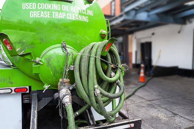 a technician pumping a grease trap in a commercial building in Orland Hills